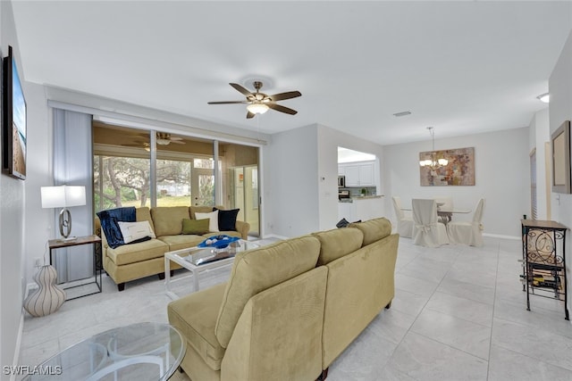 tiled living room with ceiling fan with notable chandelier