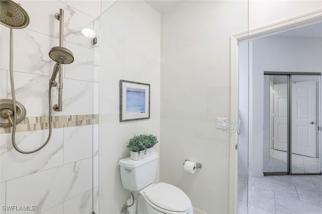 bathroom featuring tiled shower and toilet