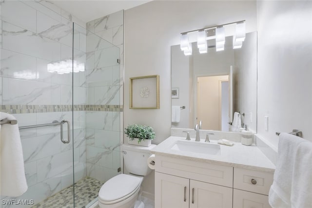 bathroom with vanity, a shower with shower door, and toilet