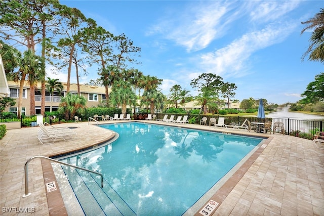 view of pool featuring a patio and a water view