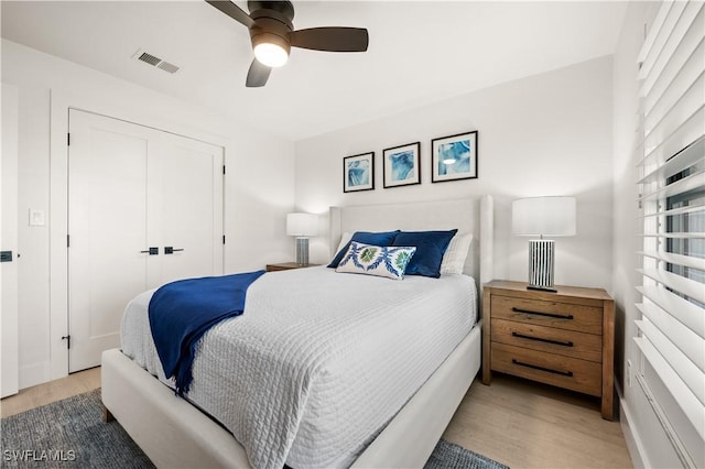 bedroom with a closet, ceiling fan, and wood-type flooring