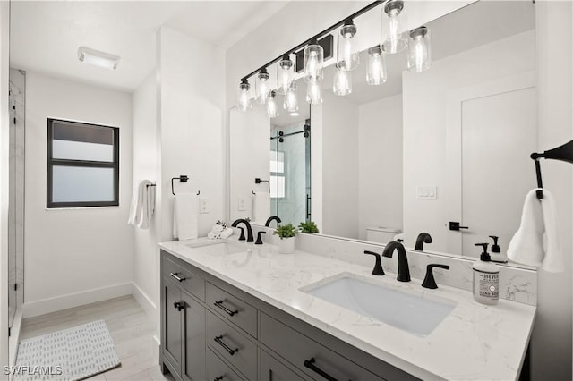 538 106th Ave N, Naples, FL 34108 - bathroom with toilet, a shower stall, baseboards, and double vanity