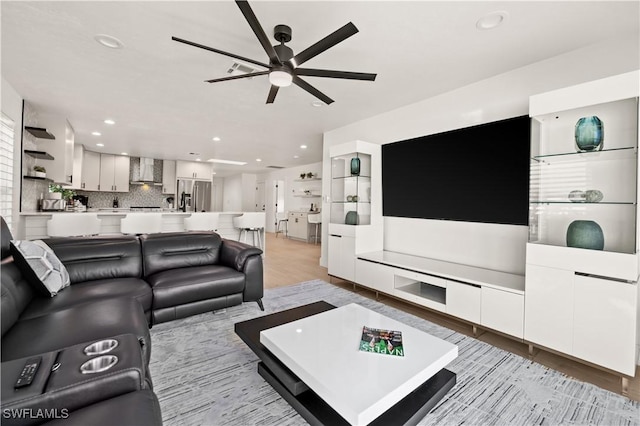 living room featuring light hardwood / wood-style floors and ceiling fan