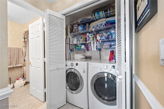 washroom with light tile patterned flooring and washer and dryer