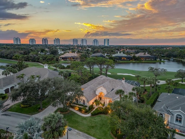 aerial view at dusk featuring a water view