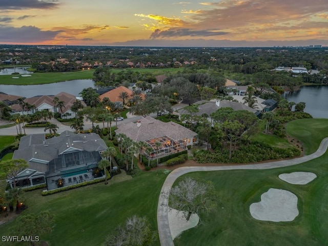 aerial view at dusk featuring a water view