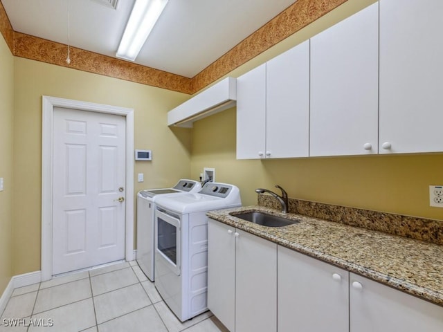 clothes washing area with cabinets, separate washer and dryer, sink, and light tile patterned floors