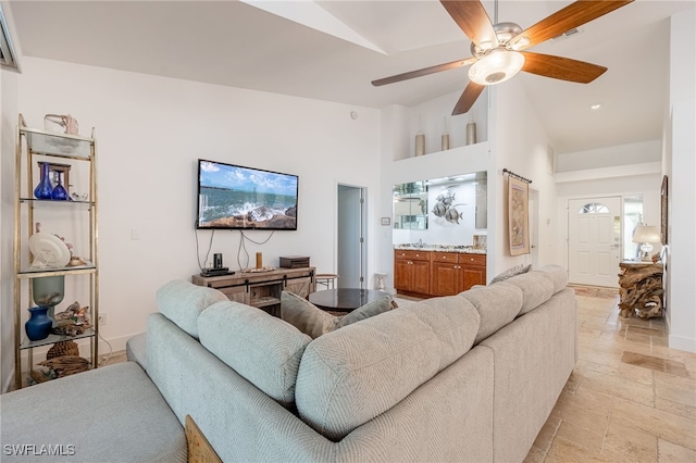 living room featuring ceiling fan and lofted ceiling