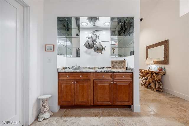 bar featuring sink and light stone countertops