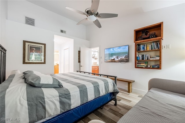 bedroom with ceiling fan, light hardwood / wood-style floors, and ensuite bath