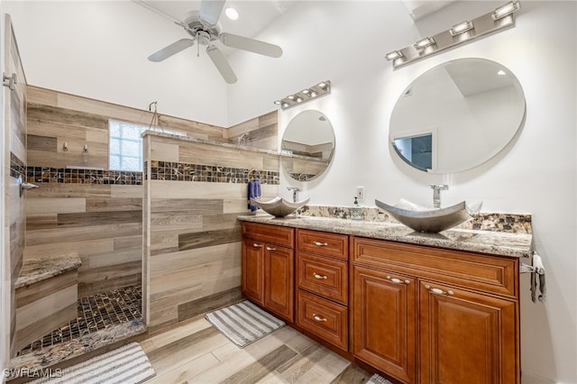 bathroom featuring ceiling fan, tiled shower, and vanity