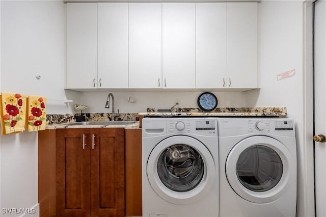 laundry room featuring sink, washer and clothes dryer, and cabinets