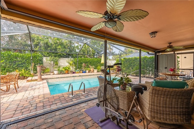 view of pool with ceiling fan, glass enclosure, and a patio