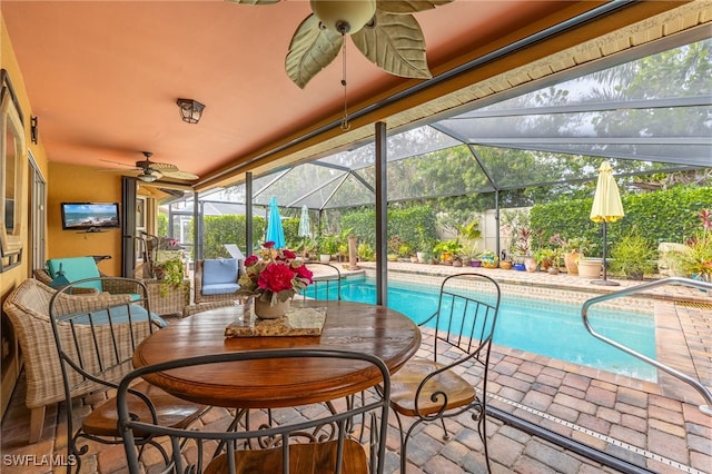 view of swimming pool featuring ceiling fan, glass enclosure, and a patio area