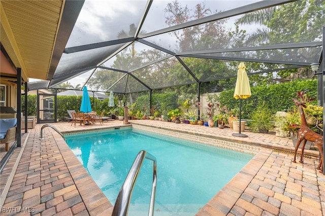 view of swimming pool featuring a patio and a lanai