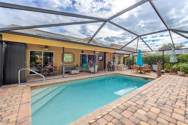 view of swimming pool with glass enclosure, a patio, outdoor lounge area, and ceiling fan