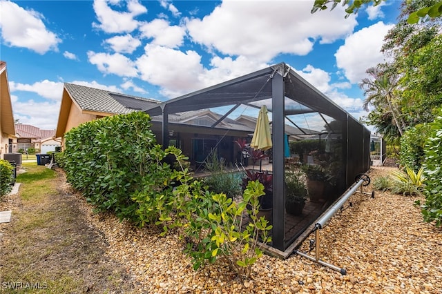 view of property exterior with glass enclosure