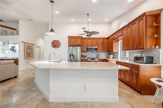 kitchen with a high ceiling, sink, a center island with sink, and stainless steel appliances