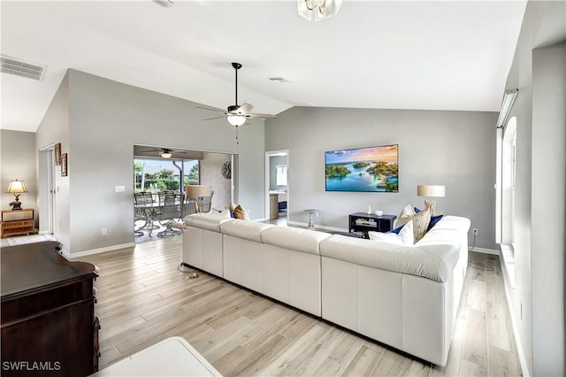 living room featuring ceiling fan, lofted ceiling, and light wood-type flooring