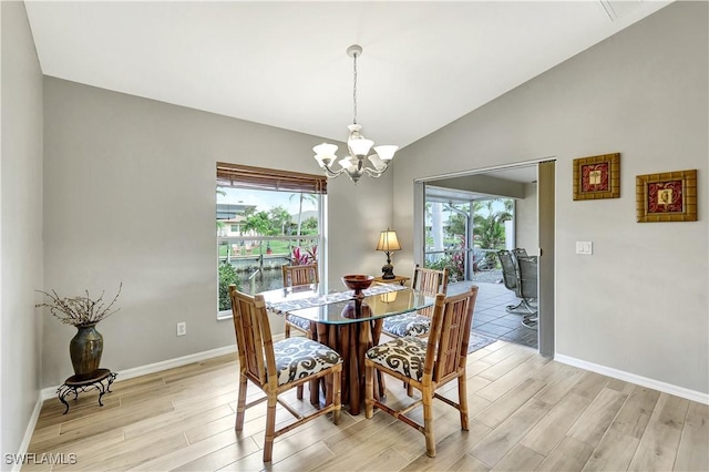 dining space featuring light wood-type flooring, vaulted ceiling, and a chandelier