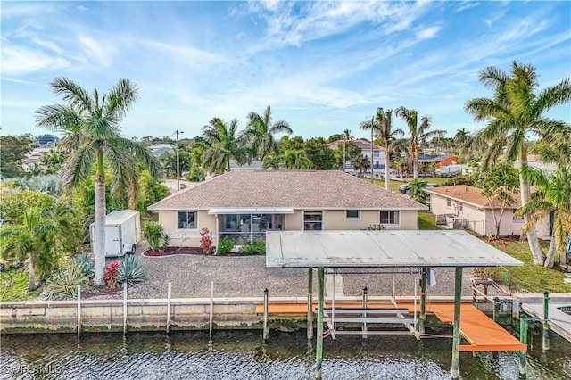 rear view of property featuring a water view and a storage shed