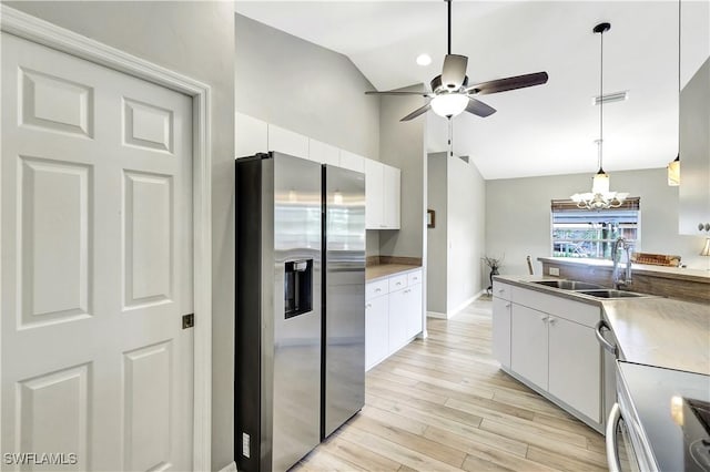 kitchen featuring sink, white cabinetry, stainless steel appliances, and hanging light fixtures