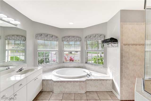 bathroom featuring vanity, tiled tub, and tile patterned floors