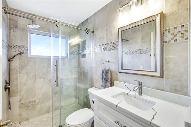 bathroom featuring a shower with door, toilet, and vanity