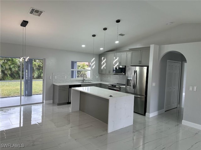 kitchen with stainless steel appliances, gray cabinetry, hanging light fixtures, and a center island