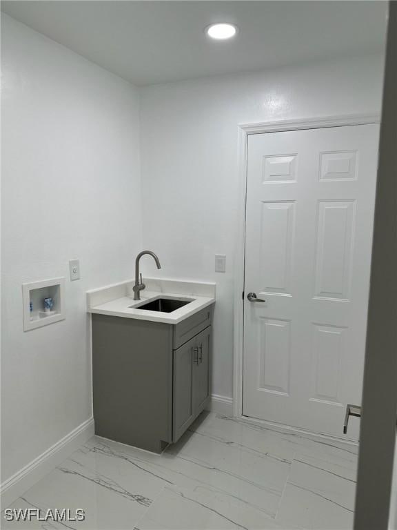 clothes washing area with sink and hookup for a washing machine