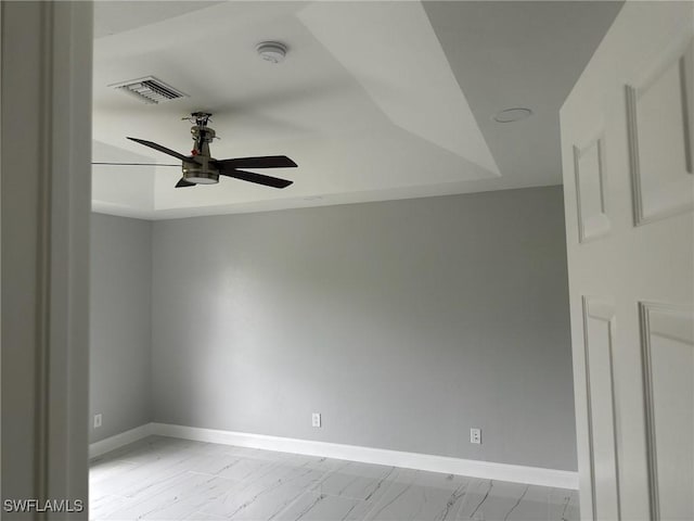 unfurnished room featuring ceiling fan and a tray ceiling