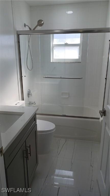 full bathroom with vanity, toilet, and bath / shower combo with glass door