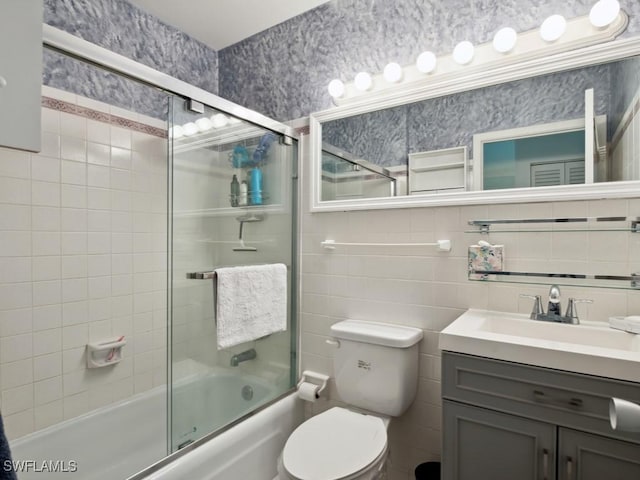 full bathroom with tasteful backsplash, toilet, combined bath / shower with glass door, and tile walls