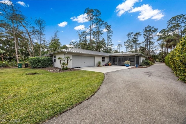 ranch-style house featuring a garage and a front lawn