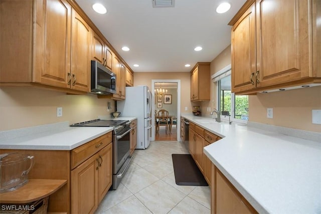 kitchen with an inviting chandelier, sink, light tile patterned floors, and appliances with stainless steel finishes