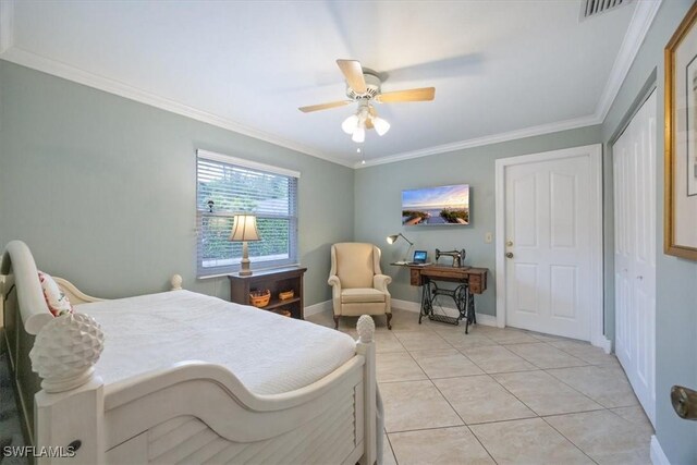 tiled bedroom featuring ornamental molding, ceiling fan, and a closet