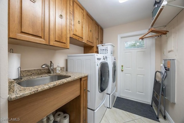 laundry room with sink, light tile patterned floors, cabinets, and washer and dryer