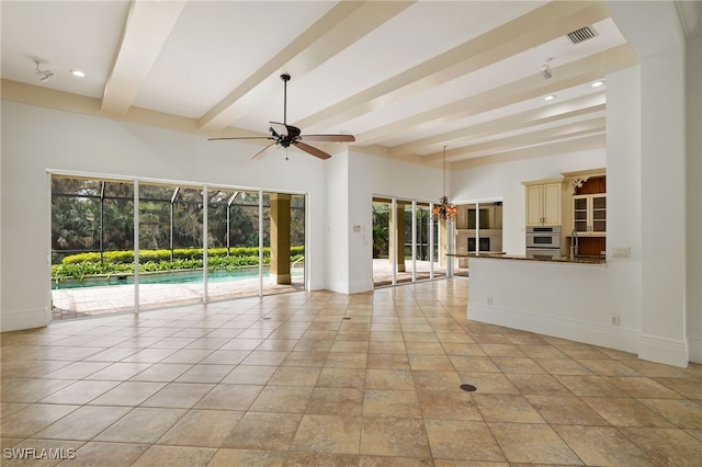 unfurnished living room featuring ceiling fan, a wealth of natural light, and beam ceiling