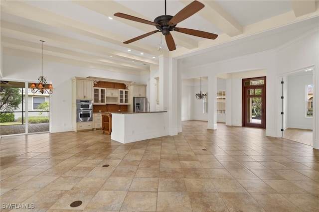 unfurnished living room featuring a healthy amount of sunlight, beamed ceiling, ceiling fan with notable chandelier, and light tile patterned flooring