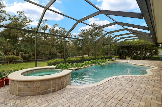 view of pool with glass enclosure, a patio area, and an in ground hot tub