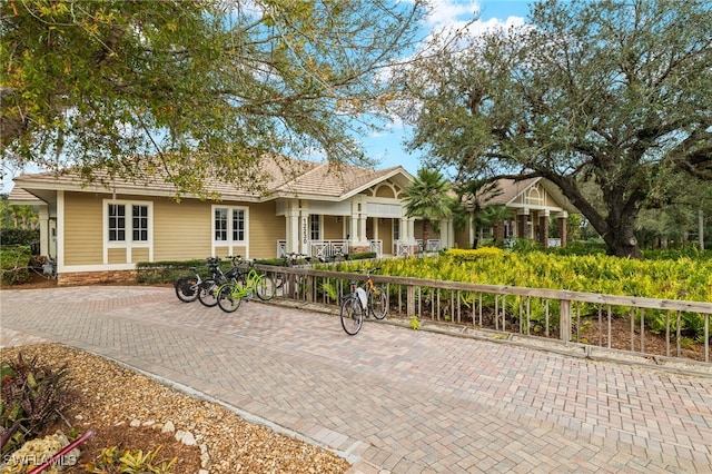 ranch-style home with a porch and a fenced front yard