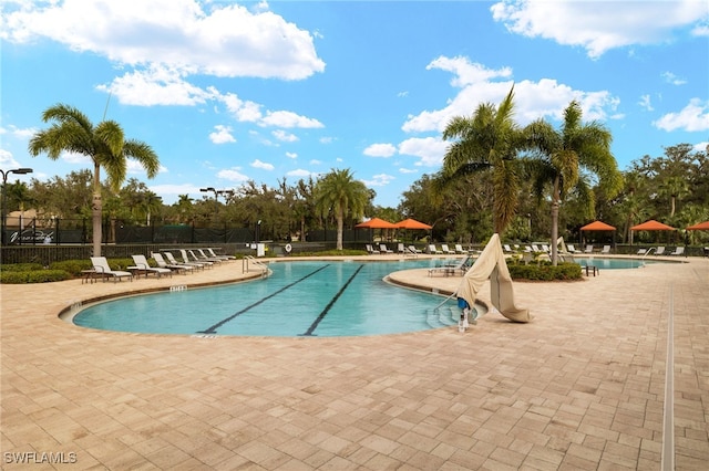 pool featuring fence and a patio area