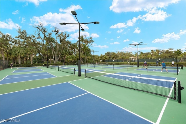 view of tennis court with community basketball court and fence