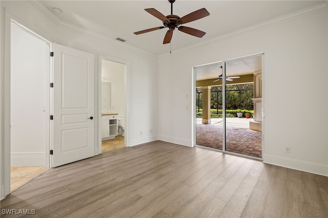 empty room with ornamental molding and light hardwood / wood-style flooring