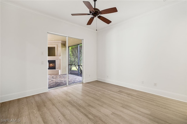 empty room with light wood-type flooring, ceiling fan, and crown molding