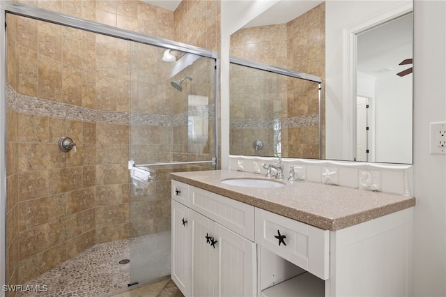 bathroom featuring ceiling fan, an enclosed shower, and vanity