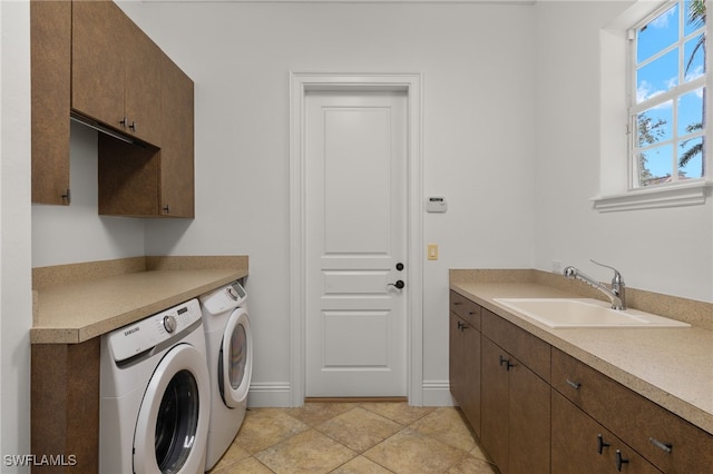 washroom featuring sink, light tile patterned flooring, independent washer and dryer, and cabinets