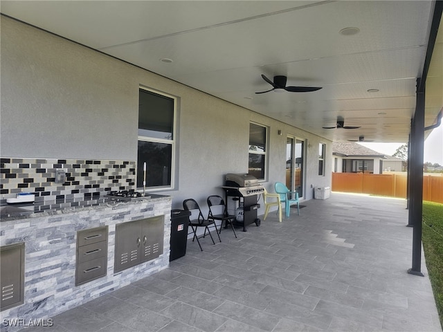 view of patio / terrace featuring ceiling fan, an outdoor kitchen, and area for grilling