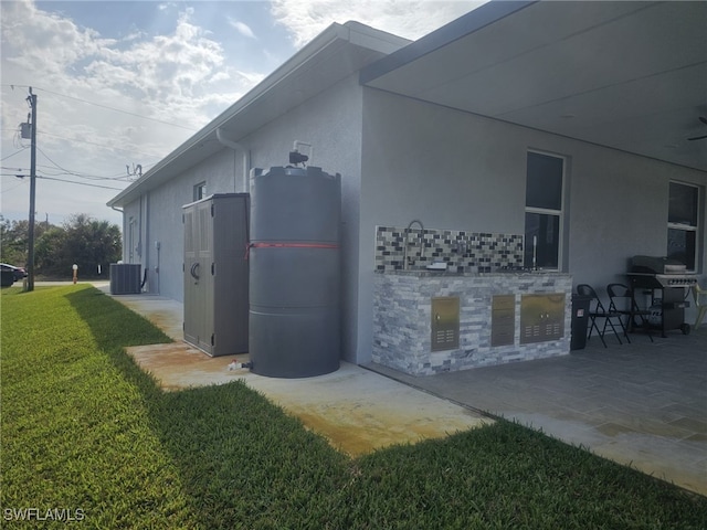 view of home's exterior with central AC and a yard