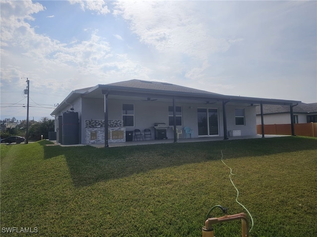 rear view of property featuring a lawn, central AC unit, and a patio